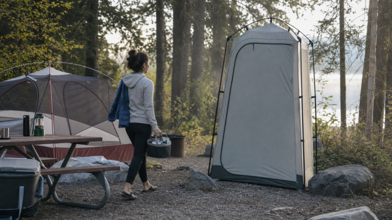 camping privacy shelter set up beside a family campsite at dawn
